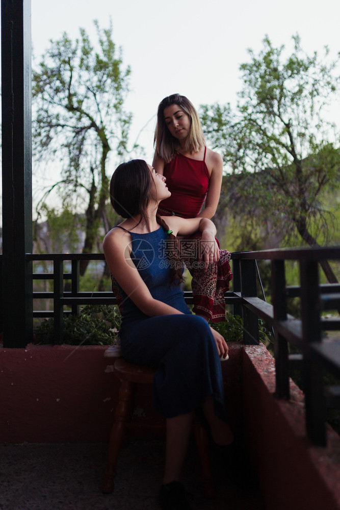两个年轻的天主教女青年在阳台上观看日落的光芒时尚白种人他们的图片
