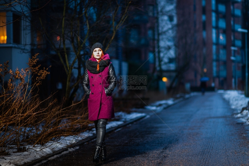 优雅的帽穿着冬衣迷人女背景是城市之夜女士图片