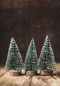 圣诞快乐马树和雪落在老木桌上黑棕褐木墙壁在冬假贺卡上木制的问候十二月图片