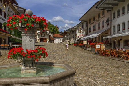经过瑞士弗里堡州格鲁耶雷村的Fribourg县Gruyere村主要街道和喷泉天气好美丽的广州背景