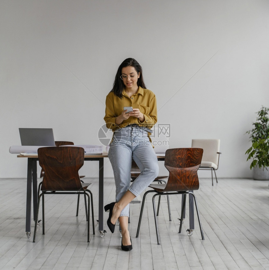 社会的现代商业女人检查她的电话工作白种人图片