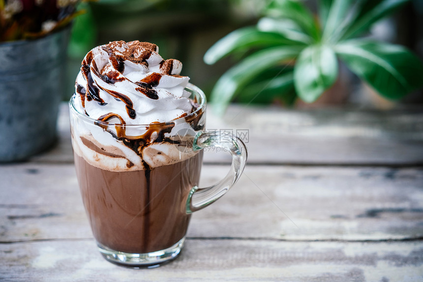 冬天咖啡店杯中的热巧克力可木背上有奶油和鲜甜的图片
