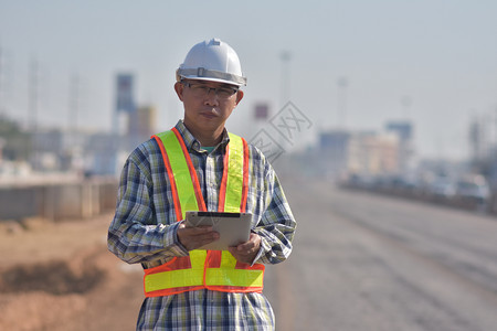 高速公路领班白色的在工地道路建设中按平板检查方式进行高级工程人图片