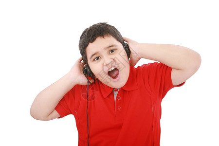 保持自然青春期前一个可爱的年轻男孩肖像在白色背景下用耳机收听音乐图片