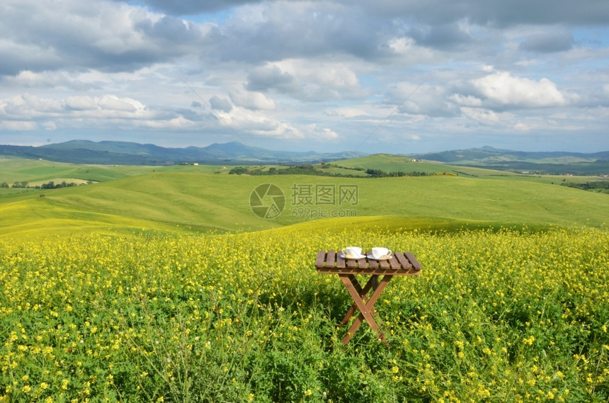 黑色的比斯科蒂与意大利Toscan风景对抗的木制桌上咖啡和罐头菜夏天图片
