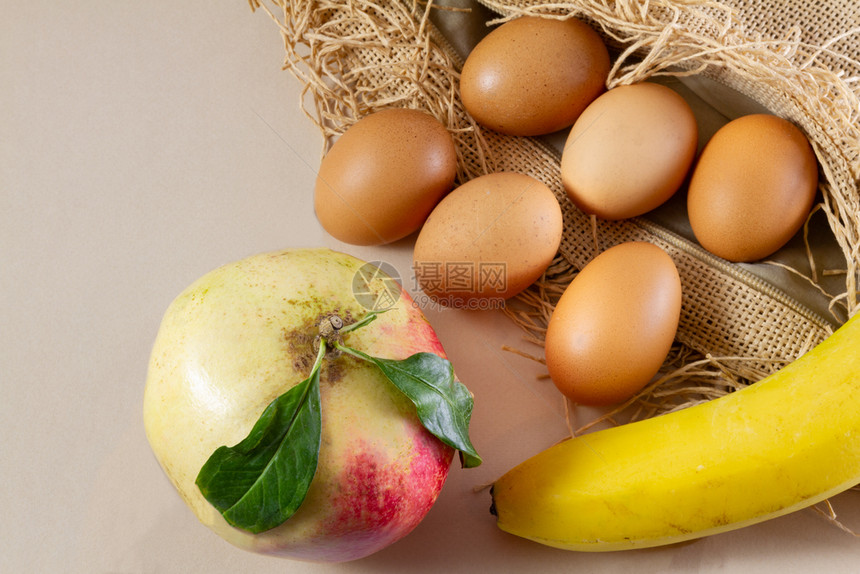 饮食6个鸡蛋1石榴和香蕉在棕色麻布和白背景传统有机食品概念示范本土的纤维图片