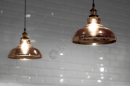 棕色的泰国以铜调制的2个旧玻璃天花板灯在室内装饰概念中模糊白瓷砖壁背景底白色电灯泡背景图片