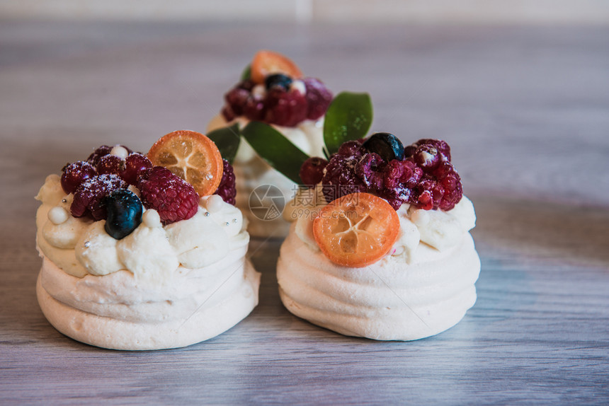 优雅烘烤的配奶油和小水果的Pavlova梅林瓜沙漠蛋糕奶油和小水果红色的图片