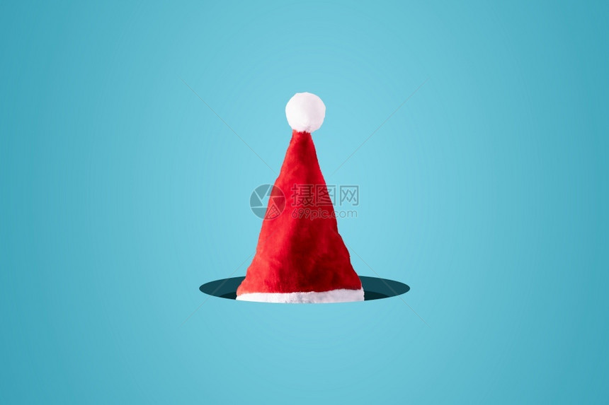 颜色派对蓝背景中的创意圣诞老人帽最小的冬季圣诞概念快乐的图片