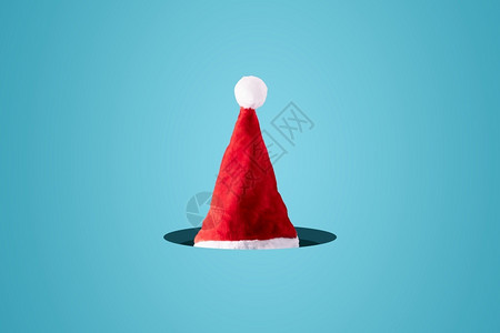 颜色派对蓝背景中的创意圣诞老人帽最小的冬季圣诞概念快乐的图片