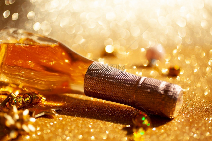 快乐的圣诞或新年配有一瓶玫瑰香槟和金色闪亮背景的花彩装饰喜庆布基和影子的侧观以及庆祝党的创造概念以庆祝圣诞节或新年瓶子葡萄酒图片