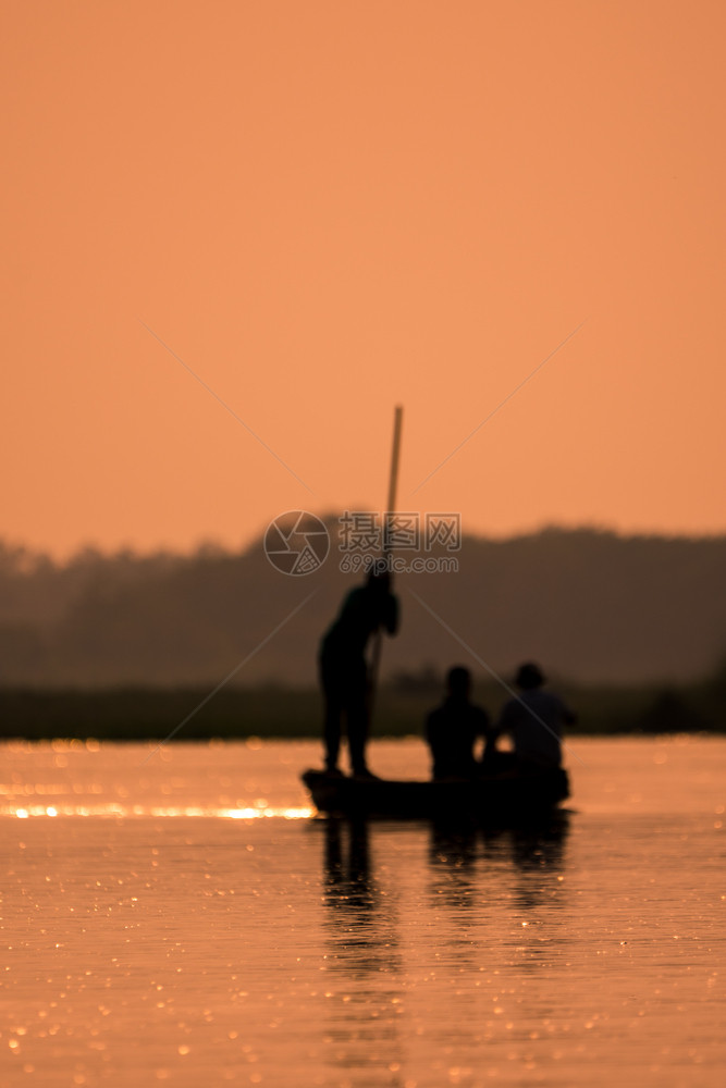 美丽的一条船上模糊男子在河边的光影中闪烁着日艺术模糊男人湖图片