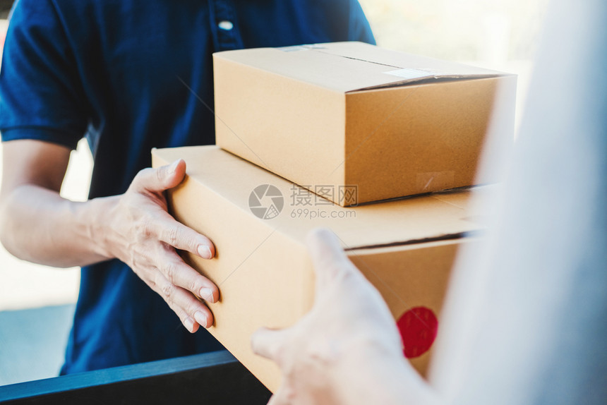 货物交一种亚洲人手接受家庭专业送货员来的运箱亚洲人手图片