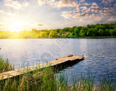 木林码头用于在日落下湖边捕鱼在日落下湖边捕鱼阳光水河图片