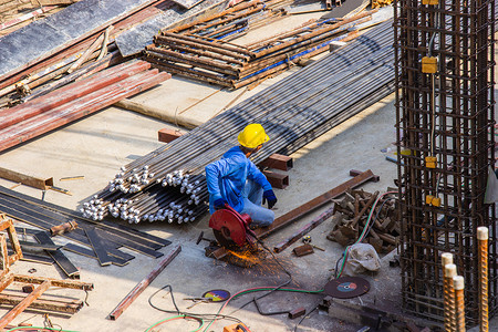 帽子男人工在地区建筑大楼内使用电工业钢切割机进行区域建筑施工管道背景图片