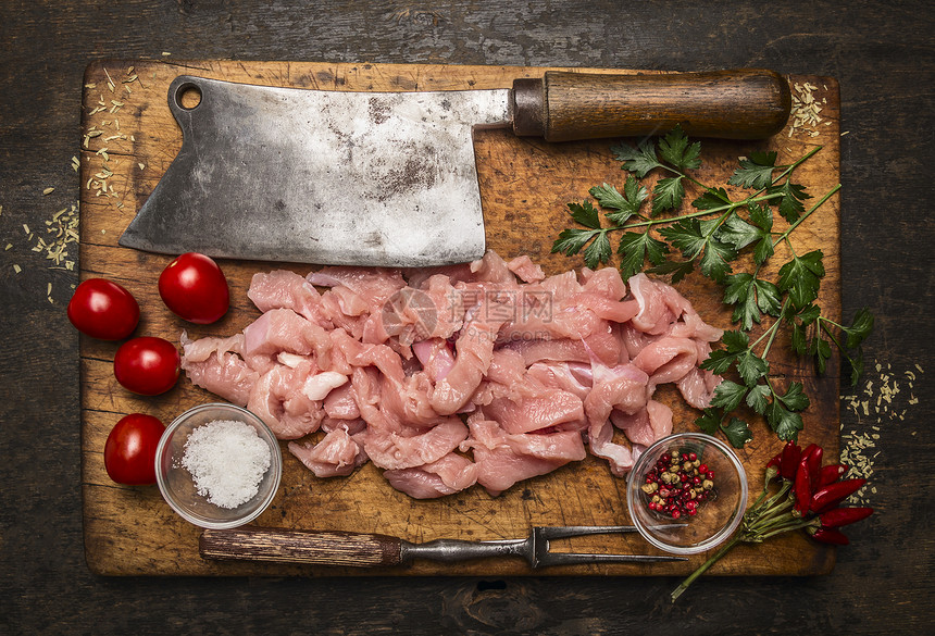 新鲜的健康食物烹饪火鸡肉刀面叉盐在生锈木本底顶视图的制切割板上食用成分图片