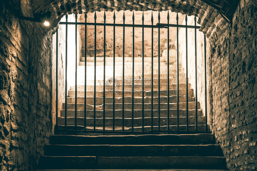 一条可怕的楼梯通往一条被铁网封锁的通道在中世纪的地牢里领导出口监狱图片