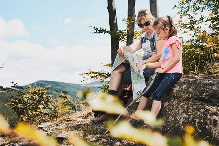 母亲和女儿在山上探亲出考察山区试验在山上度假的暑期中坐在岩石上享受夏日的山地上进行试验外部女孩人们背景图片