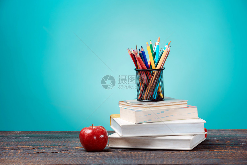 回到学校概念书有色铅笔和苹果蓝背景的彩铅笔和苹果回到学校概念书有色铅笔和苹果教科书木板知识图片