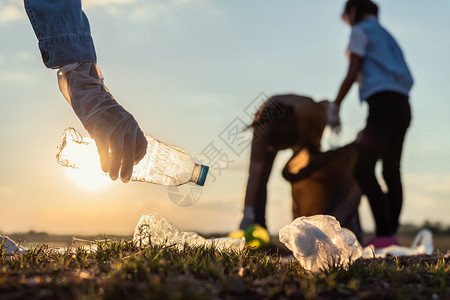 干净的在日落公园河将垃圾塑料瓶装在黑袋里的人志愿者关心环境的图片