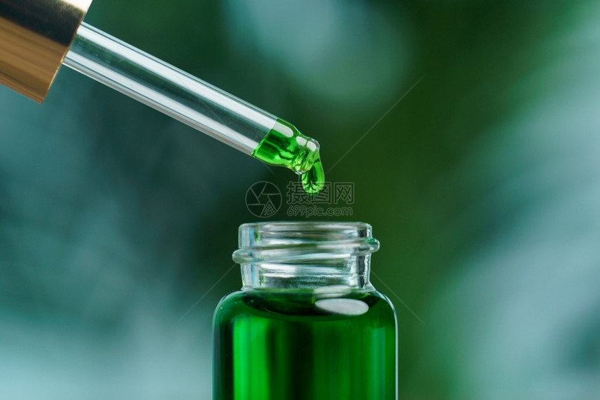 医生一个女人拿着带绿色油液实验室概念的滴水手基本降低图片