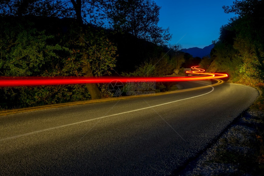 运输晚上夏夜森林中一条空路的灯光照亮夜间路边长绕风道短途横行高速公路图片
