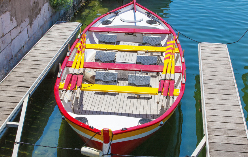 支撑停在木码头的多彩小船漂浮划图片