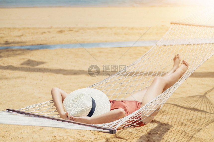 妇女在沙滩吊床上晒太阳图片