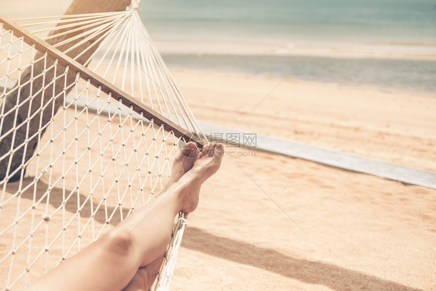 妇女在沙滩吊床上晒太阳图片