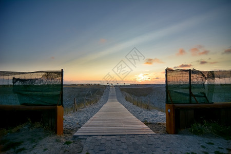 风景地平线海浪日落时去荷兰海滩的木步行道图片