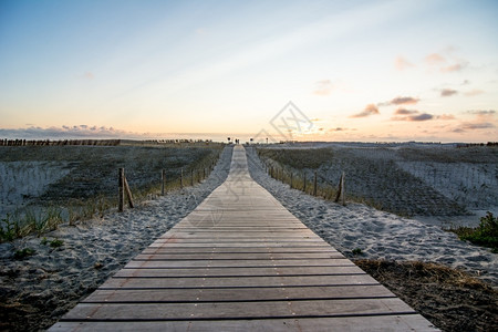 沙丘日落时去荷兰海滩的木步行道旅游海浪图片