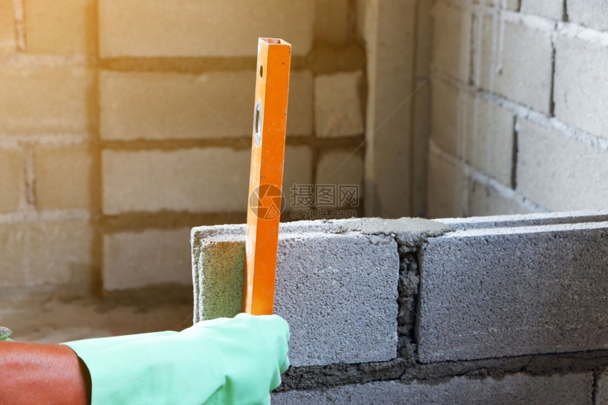 在砖块水泥墙的建筑中测量水平为垂直土砖板建筑学工作地点图片