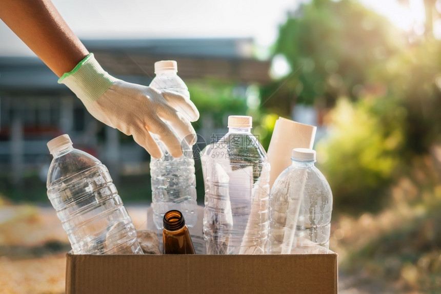 手家庭白色的将塑料装进回收袋中行清洁处理安装在垃圾瓶塑料箱内图片