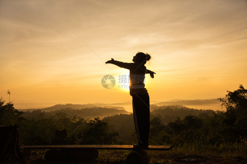 泰国请享用在山峰日出时自由欢呼的女士张开双臂黑色的图片