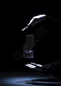 最佳错觉魔术师用杖在黑色背景下表演魔术棒戏法男人图片