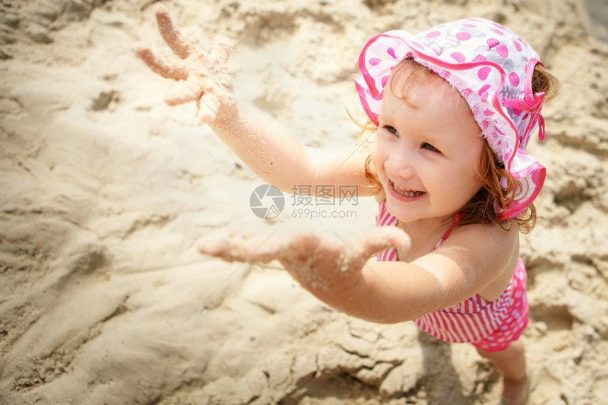 可爱的小女孩在海滩上玩手指幸福快乐的图片