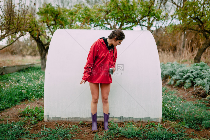 启动野花企业家果园里有雨衣的女孩在下雨时候图片