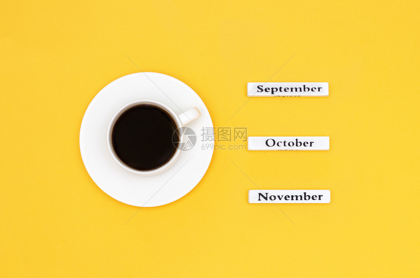 落下木制日历秋季月份910月和以黄色背景为目标的月黑咖啡杯概念顶视图平躺复制空间咖啡杯和日历月在黄色背景季节十一月图片