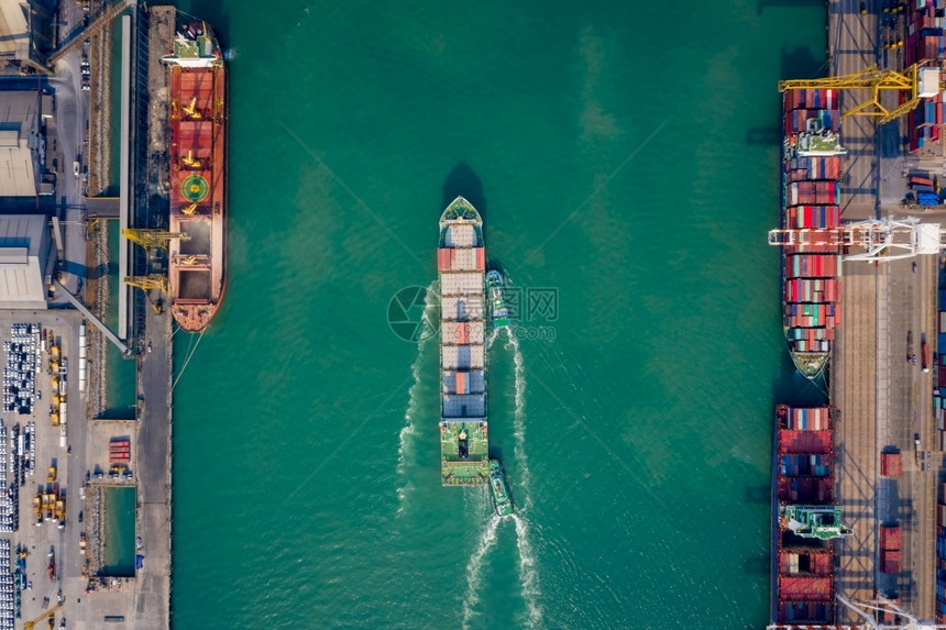 拖船将集装箱通过起重机推向码头以装载集箱用于物流进口出航运或输的空顶端视角天线重的贸易图片
