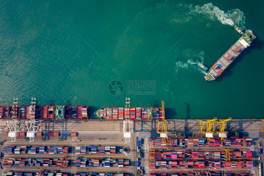 电梯为了海拖船将集装箱通过起重机推向码头以装载集箱用于物流进口出航运或输的空顶端视角图片