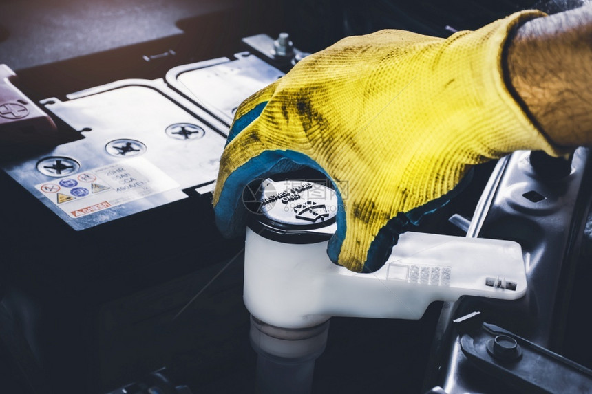 雨刮器作坊维护机械手打开或关闭挡风玻璃的防洗涤液储油罐以检查液体水平图片