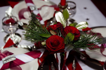 奢华餐具带有红装饰餐巾纸玫瑰银圣诞树和蜡烛的桌吃图片