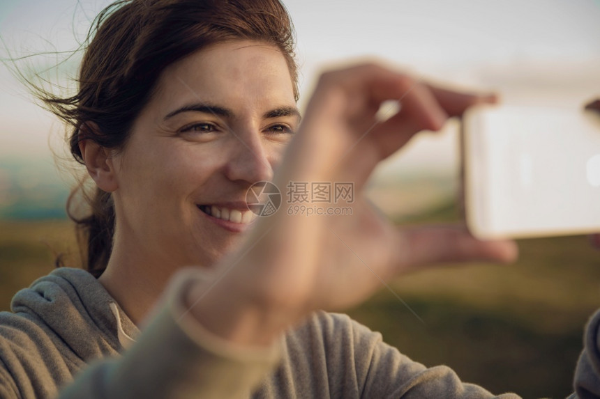 摄影服用连接自然界中的女用手机拍照妇女用手机相图片