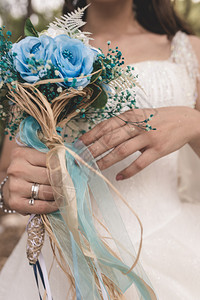 浪漫幸福绿色握着蓝花束的新娘之手图片