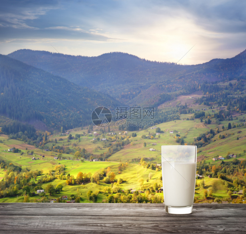 山牧场村背景木桌上的一杯牛奶自然食品的概念村背景木桌上的一杯牛奶酸饮食图片