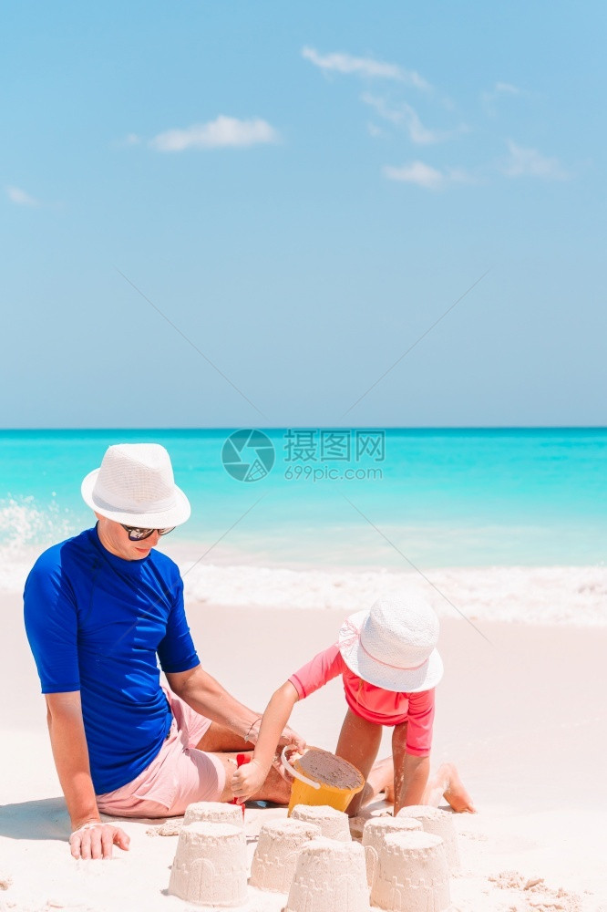 年轻的自然父亲和他孩子在热带海滩玩沙子父亲和孩在热带海滩制作沙堡家庭玩滩具喜悦图片