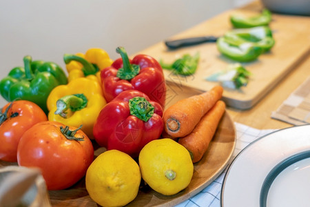 厨房置物女酒吧木板原始沙拉食品准备做厨师烹饪在现代厨房饮食和健康物概念中配有番茄柠檬胡萝卜和椒背景