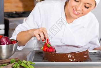 饼干面包师女厨房的糕点师装饰巧克力蛋糕图片