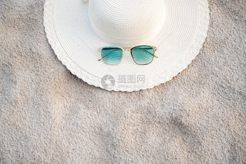 季节晴天优质的帽子和眼镜在晴朗的一天放海蓝滩上图片