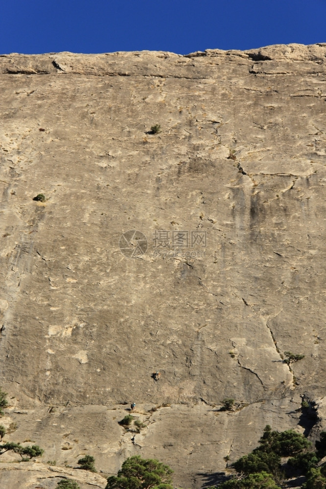 冒险高的无所畏惧在乌克兰里米亚山脉垂直户外墙壁上攀爬的登山者图片